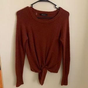 Small burnt red orange, front tie sweater there is a small hole at the top